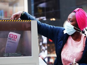 A participant at Good Riddance Day, an event in New York City's Times Square, shreds a document Monday, Dec. 28, 2020. People were invited to fill out forms to describe things from 2020 they would not miss.