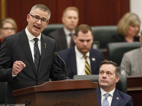 Finance Minister Travis Toews, left, delivers the budget as Alberta Premier Jason Kenney watches in Edmonton on February 27, 2020. THE CANADIAN PRESS/Jason Franson