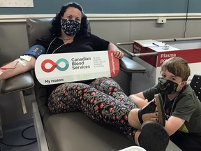 Shannon Morrison donates blood, as her son, Heydan, 9, looks on. Heydan’s immune system is compromised, leaving him susceptible to even the simplest of infections or viruses. SUPPLIED