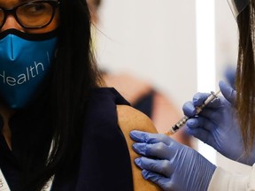 Dr. Marina Del Rios (L), from University of Illinois Hospital & Health Sciences System, reacts as she receives Chicago's first COVID-19 vaccination from Dr. Nikhila Juvvadi at Loretto Hospital, on December 15, 2020 in Chicago, Illinois.