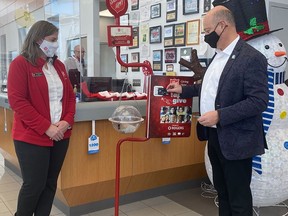 Mayor Mitch Panciuk makes the first Digital TipTap donation at the Salvation Army Christmas Kettle set up at Belleville Nissan on Wednesday. VIRGINIA CLINTON