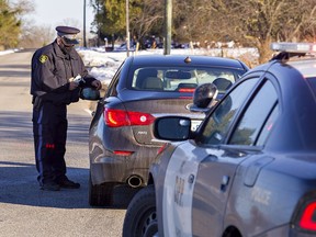 County of Brant OPP Cst. Ken Johnston holds an alcohol screening device during a traffic stop in the County of Brant.