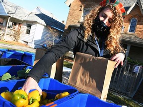 Heather Tulloch, community food connector with the Chatham-Kent Prosperity Roundtable, loads up a bag of fresh produce at the Mobile Market stop at Hope House in Chatham Dec. 3, 2020.