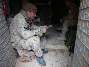 A soldier from A-Company 2 PPCLI catches up on some reading on Christmas morning at Forward Operating Base Mas'um Ghar west of Kandahar City, Afghanistan.