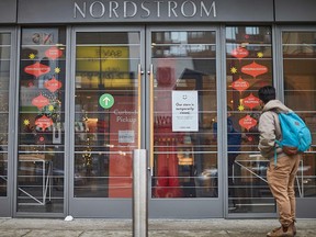 A man stands in front of the Nordstrom store, closed for in-store shopping in downtown Toronto, on November 23, 2020.