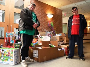 Chatham brothers Derek and Brett Gore pose for a photo with the haul of toys they donated to the Salvation Army Chatham-Kent Ministries at the Orangewood Boulevard site on Dec. 3, 2020. They purchased the toys using $5,214 they received by collecting and turning in used bottles and cans. Tom Morrison/Postmedia