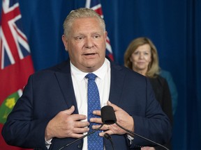 Ontario Premier Doug Ford answers questions during the daily briefing at Queen's Park in Toronto on Monday November 16, 2020 as Health Minister Christine Elliott listens.