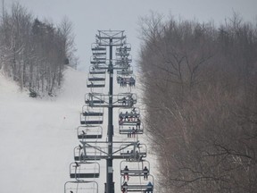 Skiers and boarders ride up the Silver Bullet chairlift on opening day at Blue Mountain Resort on Saturday, December 19, 2020.