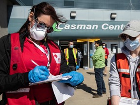 Red Cross volunteers Karen Wyonzek (left) and Sarah Callin (right) register evacuees at an evacuation centre at the Casman Centre on April 28, 2020. Greg Halinda/The Canadian Press