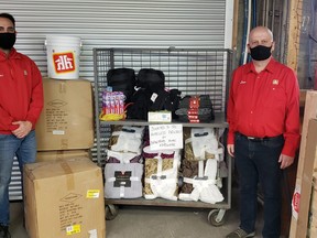 Parker Holyomes, left, assistant floor manager of Home Hardware on King George Road, and owner Dave Liesemer stand with the collection of goods they assembled to donate to sleeping bags purchased by a local customer to help the homeless stay warm.