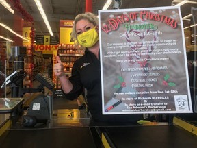 Rebecca Macdonald, organizer of the local No Frills' 12 Days of Christmas fundraiser, holds up a poster of the initiative at the grocery store near Owen Sound Monday. SUPPLIED