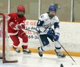 Rowan Mullin-Santone (9) of the Sudbury Wolves carries the puck while Carmine Perna (16) of the Soo Junior Greyhounds gives chase during Great North Under-18 League action at Gerry McCrory Countryside Sports Complex in Sudbury, Ontario on Saturday, December 12, 2020.