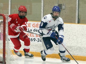 Rowan Mullin-Santone (9) of the Sudbury Wolves carries the puck while Carmine Perna (16) of the Soo Junior Greyhounds gives chase during Great North Under-18 League action at Gerry McCrory Countryside Sports Complex in Sudbury, Ontario on Saturday, December 12, 2020.