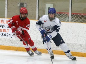 Rowan Mullin-Santone (9) of the Sudbury Wolves carries the puck while Carmine Perna (16) of the Soo Junior Greyhounds gives chase during Great North Under-18 League action at Gerry McCrory Countryside Sports Complex in Sudbury, Ontario on Saturday, December 12, 2020.