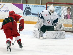 Karsen Chartier (30) of the Sudbury Wolves makes a save on Sam Lake (15) of the Soo Junior Greyhounds during Great North Under-18 League action at Gerry McCrory Countryside Sports Complex in Sudbury, Ontario on Saturday, December 12, 2020.