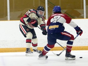 Blind River Beavers forward Jacob Kelly (94) plays a puck while Rayside-Balfour Canadians defenceman Michael Campbell (7) defends during first-period NOJHL action at Chelmsford Arena in Chelmsford, Ontario on Sunday, December 20, 2020.