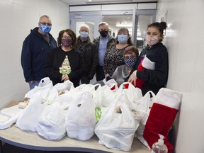 Volunteers pose next to Christmas meals distributed by the Fort McMurray Knights of Columbus at Father Turcotte School on Friday, December 25, 2020. Photo by Robert Murray
