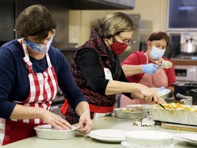 Jan Brosseau, left, Jane Butterman and Grace Magliaro package meals during Interfaith Caring Kitchen’s annual Christmas dinner at the Spirit & Life Centre in Chatham, Ont., on Wednesday, Dec. 2, 2020. (Mark Malone/Chatham Daily News)