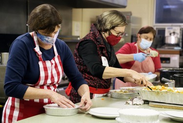 Jan Brosseau, left, Jane Butterman and Grace Magliaro package meals during Interfaith Caring Kitchen’s annual Christmas dinner at the Spirit & Life Centre in Chatham, Ont., on Wednesday, Dec. 2, 2020. Mark Malone/Chatham Daily News/Postmedia Network