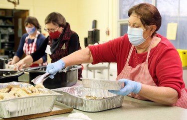 Grace Magliaro, right, Jane Butterman and Jan Brosseau package meals during Interfaith Caring Kitchen’s annual Christmas dinner Wednesday at the Spirit & Life Centre in Chatham, Ont., on Wednesday, Dec. 2, 2020. Mark Malone/Chatham Daily News/Postmedia Network