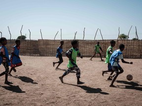 Ethiopian refugees who fled the Tigray conflict, play football in a playground set by Save the Children at Um Raquba reception camp in Sudan's eastern Gedaref province on December 3, 2020. - More than 45,000 people have escaped from northern Ethiopia since November 4, after Prime Minister Abiy Ahmed ordered military operations against leaders of Tigray's ruling party in response to its alleged attacks on federal army camps. (Photo by Yasuyoshi CHIBA / AFP)