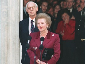 British Prime Minister Margaret Thatcher, flanked by her husband, Denis, addresses the press on Nov. 28, 1990, for the last time in front of 10 Downing Street in London prior to handing in her resignation as prime minister to Queen Elizabeth II.