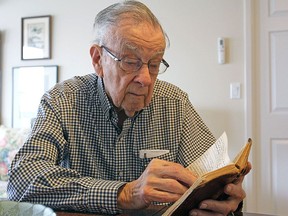 Bill Fitsell, at his home in Kingston in April 2017, reads the diary he wrote while serving in the Royal Canadian Navy during the Second World War.