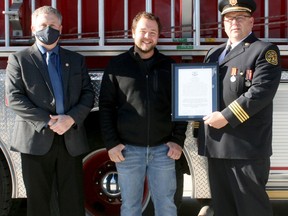 Exeter's Jake Johnson, centre, recently received a commendation from the Municipality of South Huron for his lifesaving actions Oct. 1 when he came upon a vehicle on fire with the driver inside. Johnson, who works at McCann Redi-Mix, dumped a load of sand from his dump truck onto the fire to extinguish it. Presenting the commendation to Johnson on Nov. 28 at the Exeter fire hall were Mayor George Finch, left, and Fire Chief Jeremy Becker, right. Scott Nixon