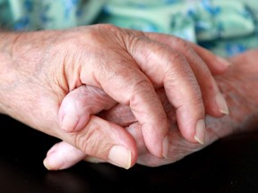 A man holds the hand of his wife, who suffers dementia after a stroke, in this file photo.
Julie Oliver/POSTMEDIA