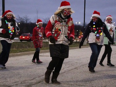 Members with the Sarnia Outta-Liners Line Dance Group perform as one of the entries in the drive-thru Santa Claus Parade at  Lambton College Dec. 5 in Sarnia. There was bumper-to-bumper traffic over three hours to see stationary displays in this year's modified parade event, organizers with the Sarnia Kinsmen Club said. (Tyler Kula/The Observer)
