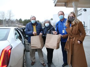 Finlandia SISU Foundation board member Paul Villgren, left, loads bags of food into his car with the help of Patricia Clizia, executive director of the Finlandia SISU Foundation, David Munch, CEO of Finlandia Village, and  Maureen McNamara, foundation board chair, at A Taste of Finland at Home at Finlandia Village in Sudbury, Ont. on Thursday December 3, 2020. The Finlandia SISU Foundation initiative raised more than $20,000 for COVID-19 needs at Finlandia Village. A total of 263 meals were ordered by community members for curbside pick-up at Finlandia on Thursday. The event was sponsored by the Lougheed Foundation.