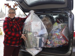 Diane Auger, manager of The Bargain Shop on Algonquin Boulevard, attempts to pack some of the bags of toys collected on Saturday during the annual Christmas toy drive hosted by the Timmins Police Service, Timmins and District Victims' Services and The Bargain Shop.

RICHA BHOSALE/The Daily Press