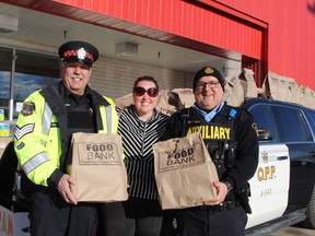 Sharon Lively was among those who donated non-perishable food items towards the Cram-a-Cruiser food drive that was held in December 2018, when this photo was taken. Lively is seen here with auxiliary sergeants Robert Ferri, left, with Timmins Police Service, and Tibor Lesko, with the South Porcupine OPP.

RON GRECH/THE DAILY PRESS
