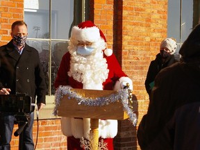 A masked Santa Claus brought greetings Saturday to St. Thomas, joining Elgin––Middlesex––London MPP Jeff Yurek, left, and MP Karen Vecchio, right. Santa returns this weekend for the reverse Santa Claus parade Friday, Saturday and Sunday at Pinafore Park. (Eric Bunnell/Special to the Times-Journal)