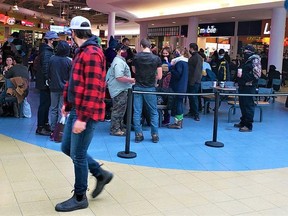 A lone patron walking past the food court at the Quinte Mall takes notice of a small crowd gathered around a dining table Saturday afternoon that sparked complaints among shoppers. Security guards were called in to disperse the group which was not social distancing. DEREK BALDWIN