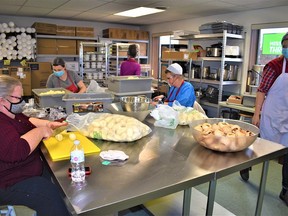 Taylor Bare, Salvation Army food-services coordinator, far right, and a team of volunteers prepared more than 300 meals in the kitchen at the Salvation Army centre on Pinnacle Street in Belleville as part of the charity organization's Christmas dinner Dec. 25. DEREK BALDWIN