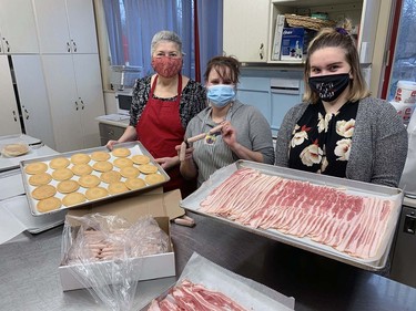 Theresa Lukac (left), Tiffany Dunham and Taylor Cross work in the kitchen of the Polish Hall on Pearl Street on Sunday morning to prepare pancakes, eggs, waffles, bacon and sausage for Breakfast with Santa. The event gave local children and their families a chance to enjoy some Christmas cheer and wave to Santa and Mrs. Claus. Vincent Ball