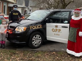 Nine-year-old Logan Good and his younger sister, Zoe, are visited by Mrs. Claus and Norfolk OPP Const. Ed Sanchuk on Saturday. (CONTRIBUTED)