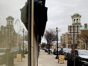 Brockville city hall is reflected in the graffiti-sprayed window of the former Woolworth's building, which the city acquired for $500,000. (FILE PHOTO)