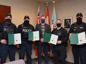 MP Michael Barrett (middle) presents certificates to (from left) Const. Dustin Gamble, Const. Geoff Fearon, A/Sgt. Eric Ruigrok and Const. Ross McCullough of the Brockville Po;ice Service in recognition of their life-saving efforts in separate incidents this fall. Absent for the photo was Sgt. Shawn Borgford.
BPS photo