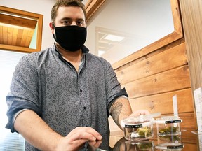 Don Tetrault Jr., owner of Bud Bank Inc., holds one of the jars holding dried cannabis flower at the Chatham store.
