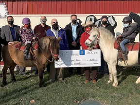 The 100+ Men Who Care Chatham-Kent presented a $8,600 cheque to TJ Stables for its Acceptional Riders therapeutic riding program on Dec. 11. Shown standing here, from left to right, are Jon Eenink, David Dawson, Chatham-Kent Mayor Darrin Canniff, Chris Summerfield, Ed Carney, Chris Appleton, TJ Stables owner Terry Jenkins, Dane Appleton and Daryn Trainor. On the horses are Margaret, left, and Trevon.