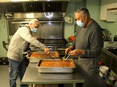 Ralph La Bonte, left, and Terry Shadd prepare the beans and wieners that were on the menu at the Campbell AME Church's weekly soup kitchen in Chatham on Wednesday. Ellwood Shreve/Chatham Daily News/Postmedia Network