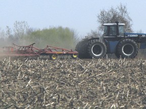 A tractor tills a field north of Woodstock.