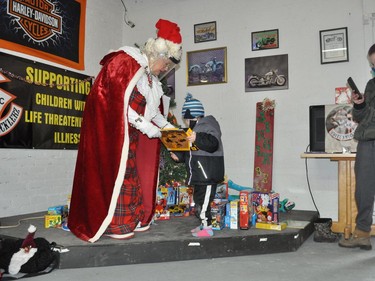 Mrs. Claus presenting Logan with some of the gifts on Saturday December 12, 2020 in Cornwall, Ont. Francis Racine/Cornwall Standard-Freeholder/Postmedia Network