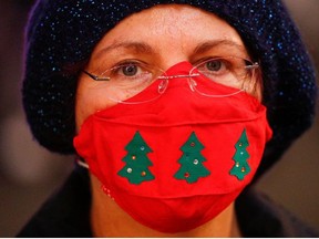 A person wearing a Christmas-themed protective mask looks on one day before Italy goes back to a complete lockdown over the Christmas period as part of efforts put in place to curb the spread of the coronavirus disease (COVID-19), in Rome, Italy, December 23, 2020.