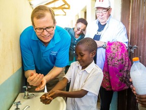 President and CEO of UNICEF Canada David Morley teaches a young boy how to wash his hands in Mbeya, Tanzania.