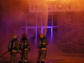 Flames spew out the upper floor windows of a building at Bath Road and Westdale Avenue as fire destroyed the former flea market building on Dec. 8.