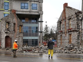 Officials from In8 Developments look through the rubble of the bakery building at the corner of Princess and Victoria streets in Kingston. The building, which dates back to the 1840s, collapsed at approximately 4:30 a.m. on Friday. The building was adjacent to a large condominium building under construction by In8 Developments.