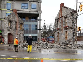 Officials from IN8 Developments look through the rubble of a former bakery building at the corner on Princess and Victoria streets in Kingston that collapsed at around 4:30 a.m. on Dec. 25. The building, which IN8 said dates back to the 1830s, was adjacent to a large condominium building under construction by IN8 Developments.
